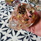 "Close-up of pink resin skull with natural pinecones and botanical accents"