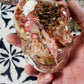 Side view of pink resin skull showing detailed lacing and clear resin finish